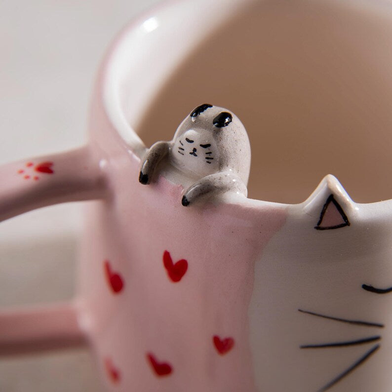 Tasse en céramique rose kawaii avec visage de chat et motifs cœur, peinte à la main