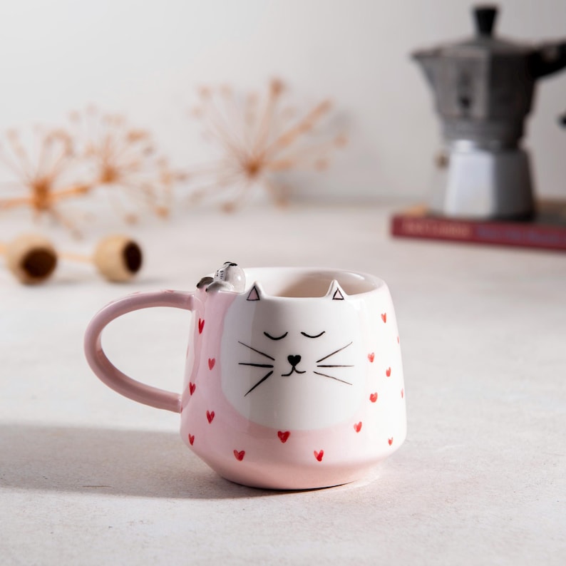 Tasse en céramique rose kawaii avec visage de chat et motifs cœur, peinte à la main