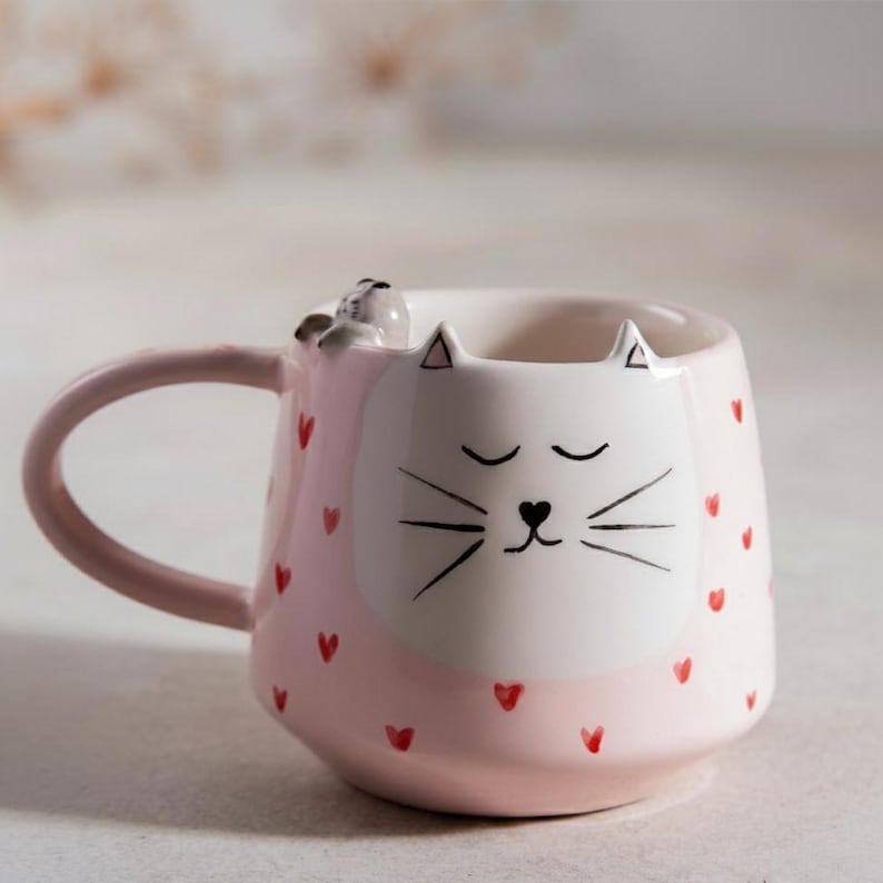 Tasse en céramique rose kawaii avec visage de chat et motifs cœur, peinte à la main